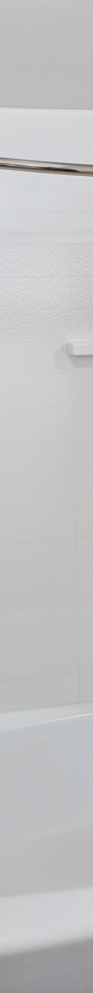 White tiled bathtub and shower with curtain