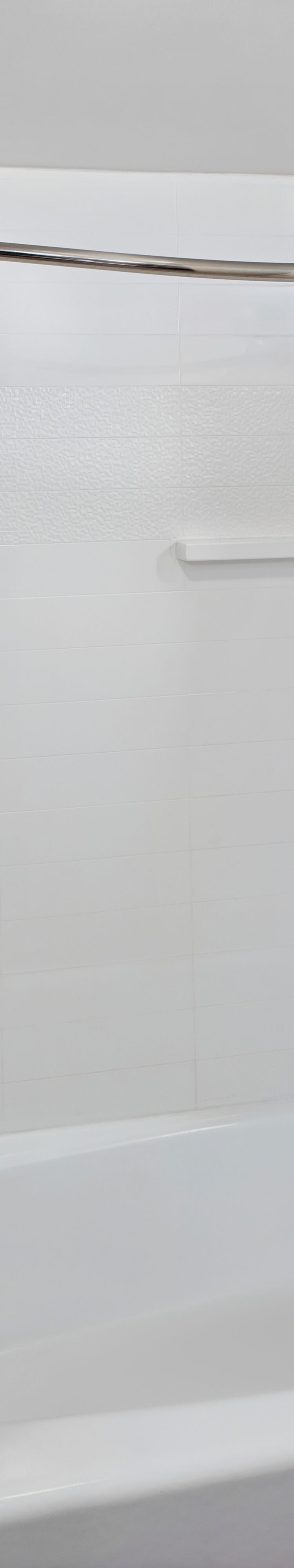 White tiled bathtub and shower with curtain