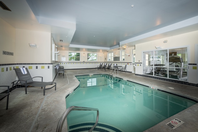 Indoor swimming pool with patio furniture. 