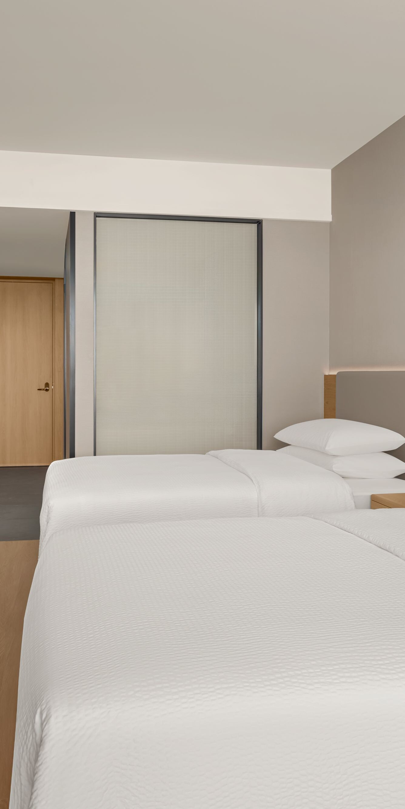 Two beds with TV and wall-mounted desk