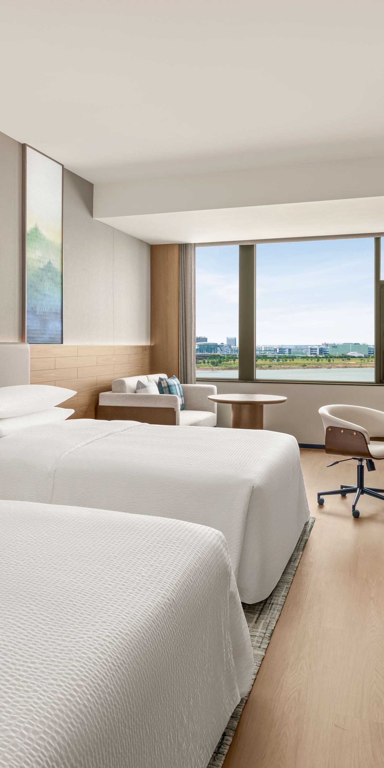 Two beds with desk and window view
