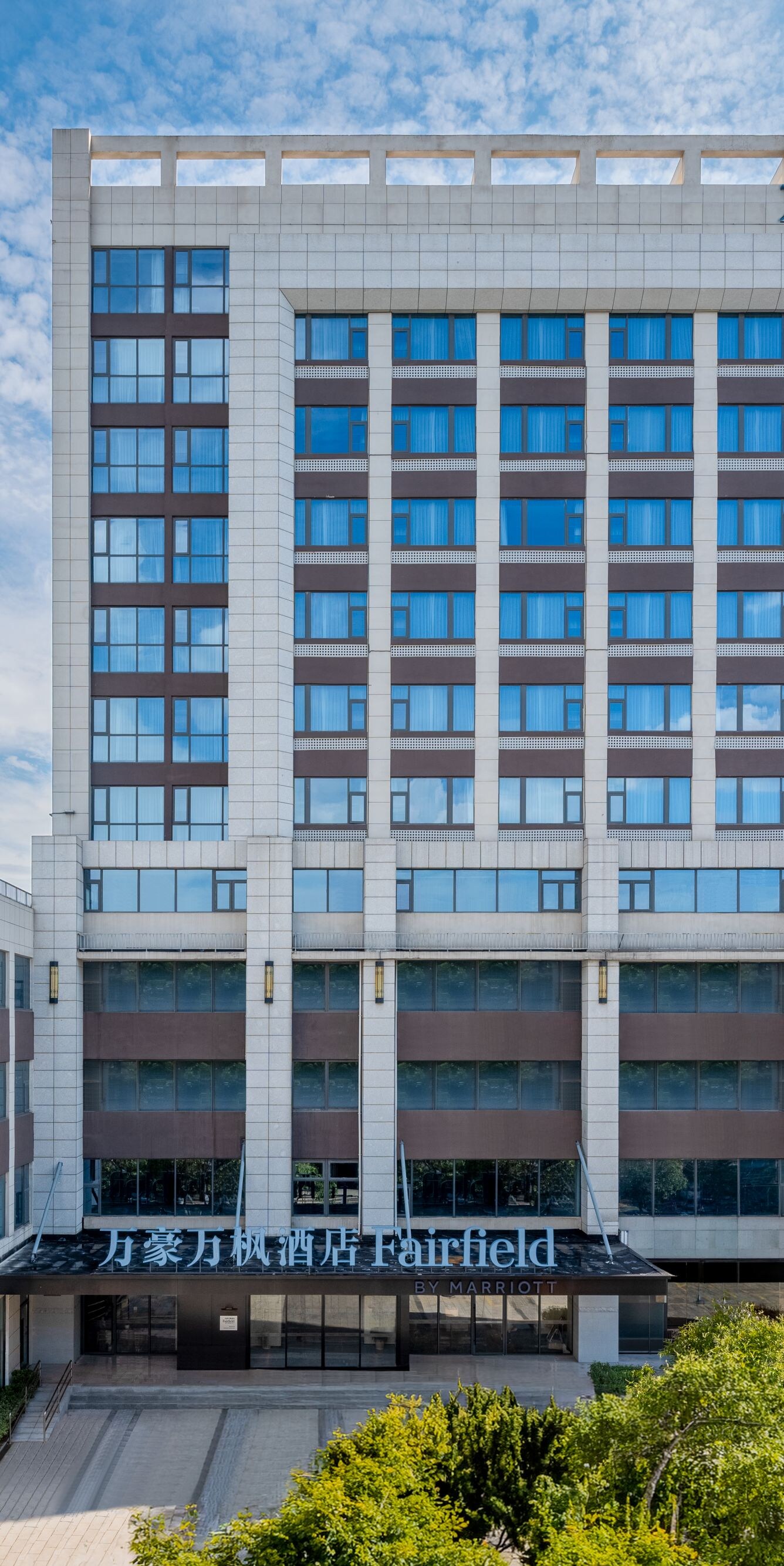 Hotel exterior with trees and entrance canopy