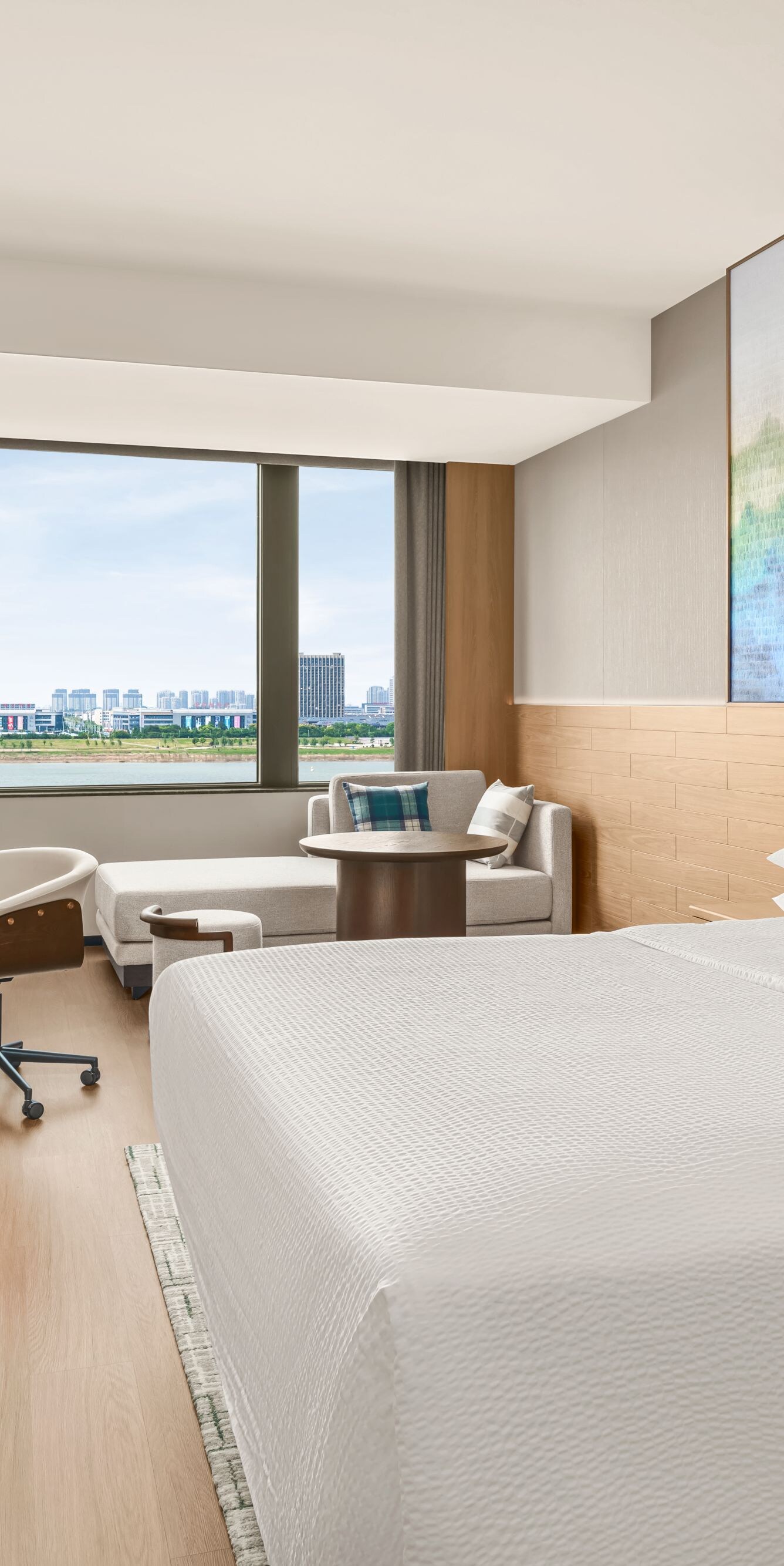 King bed with desk, chair, and window view