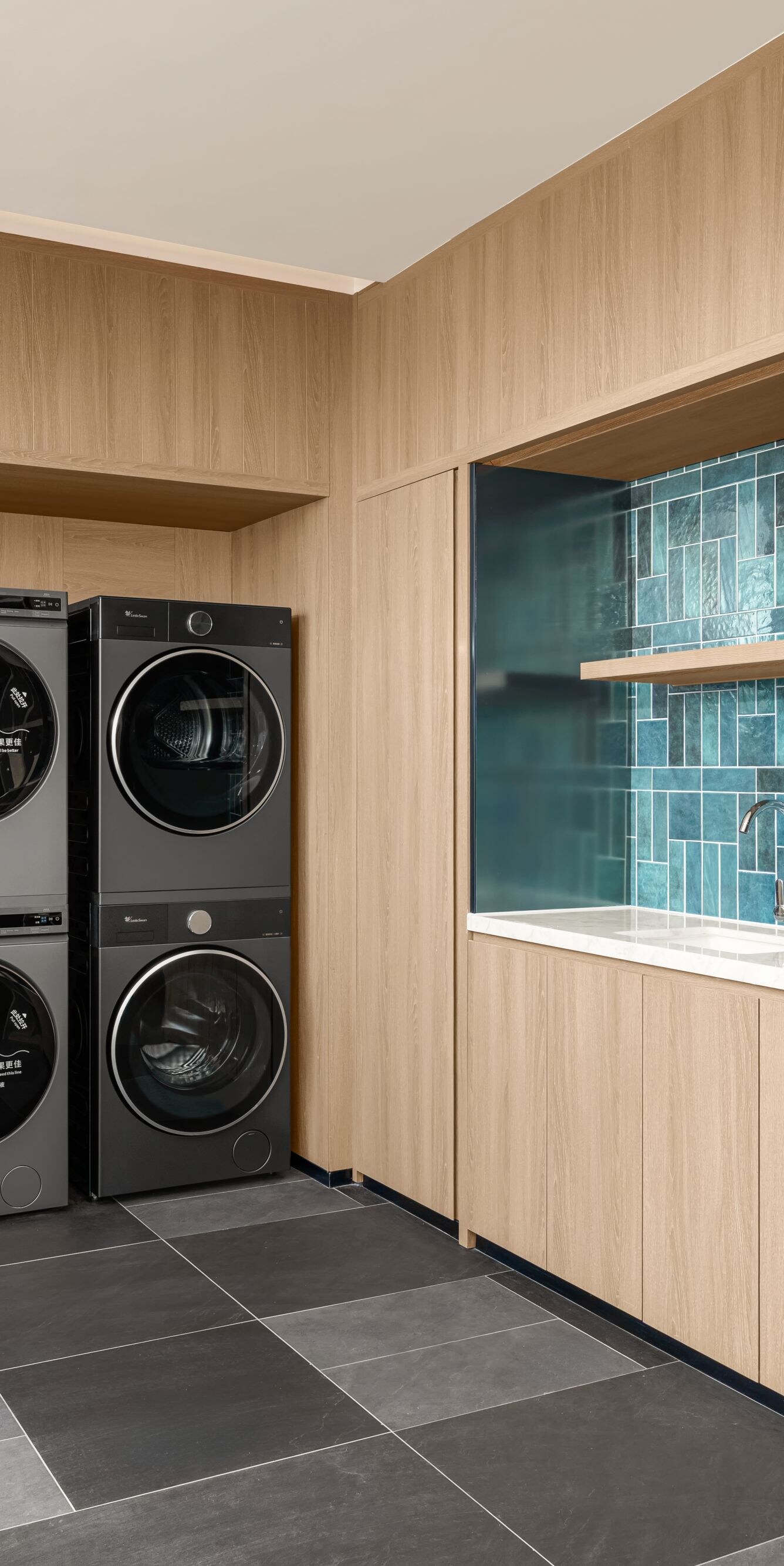Laundry room with washers, dryers, and shelves