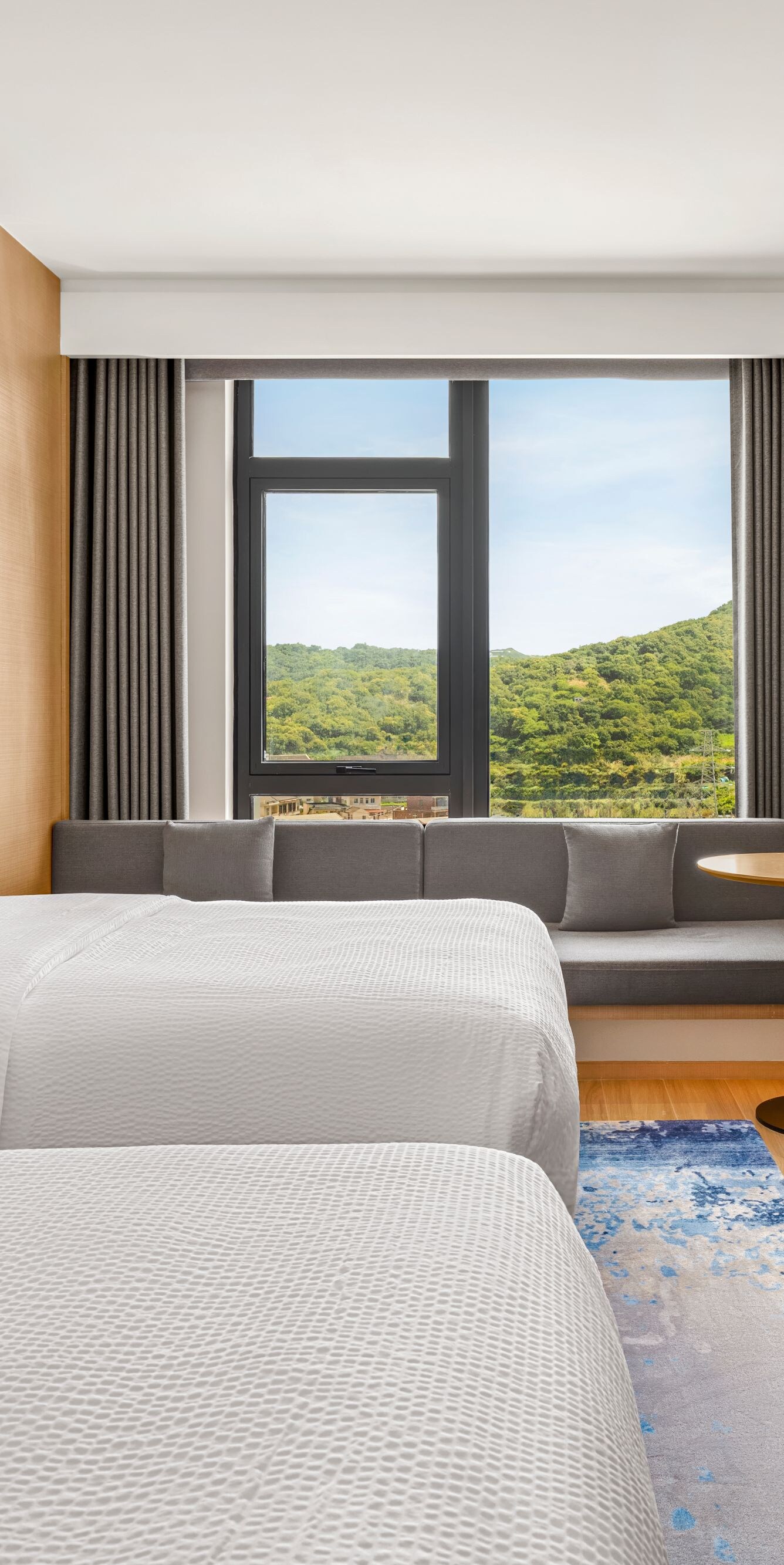 Two beds with sofa, TV, and window view