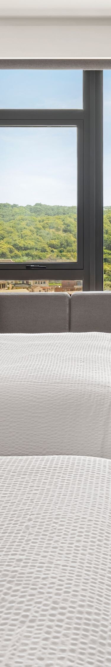 Two beds with sofa, TV, and window view