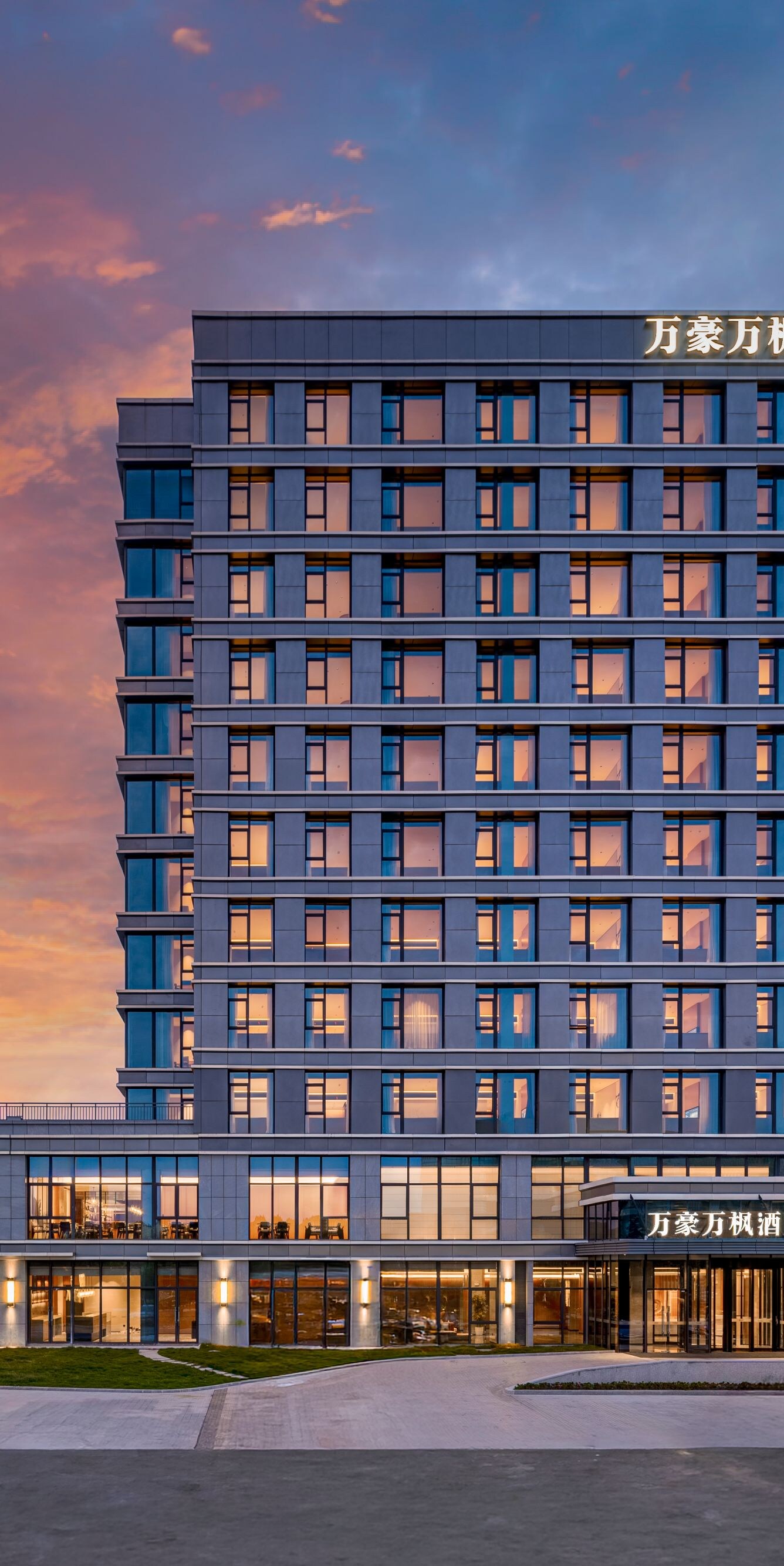 Hotel exterior at dusk with illuminated facade