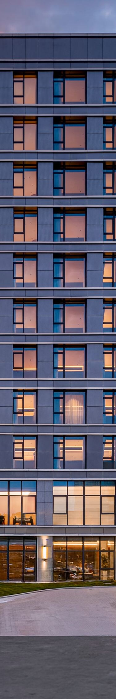 Hotel exterior at dusk with illuminated facade