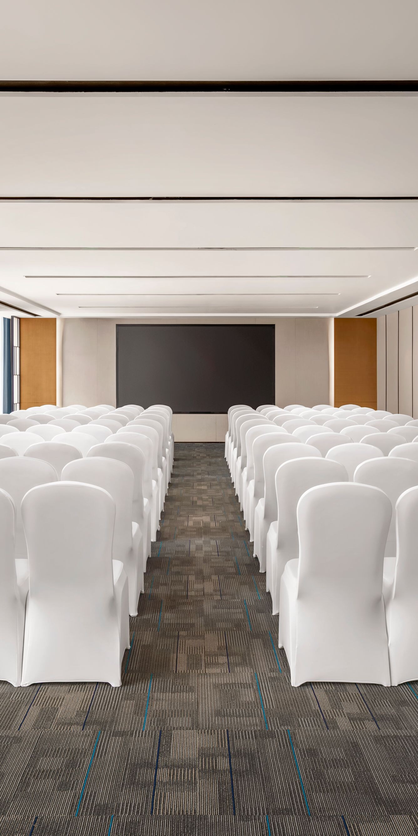 Meeting room with rows of chairs and screen