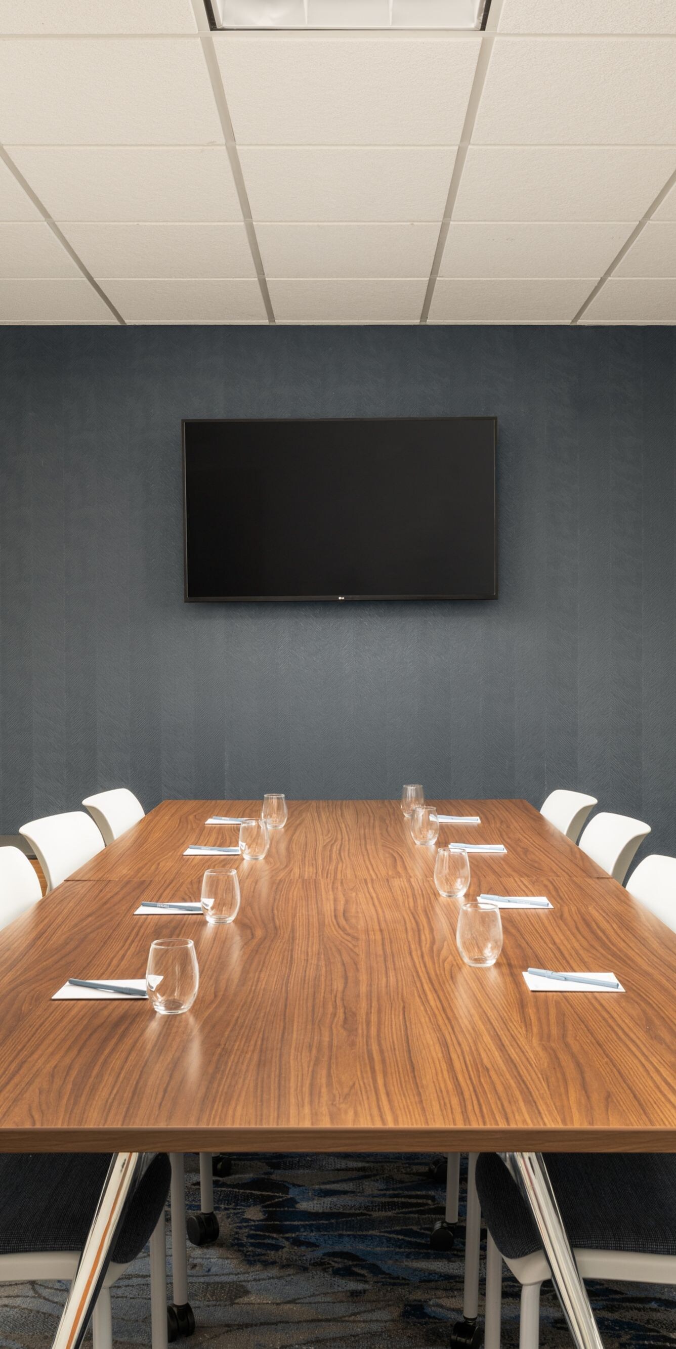boardroom table with TV on wall