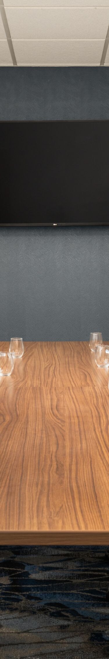boardroom table with TV on wall