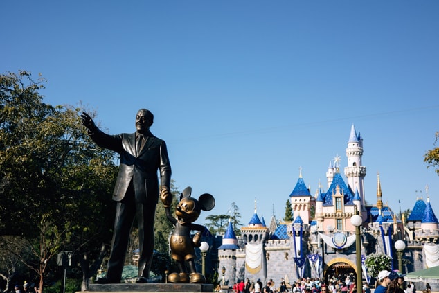 Statue of Walt Disney and Micket Mouse by a castle
