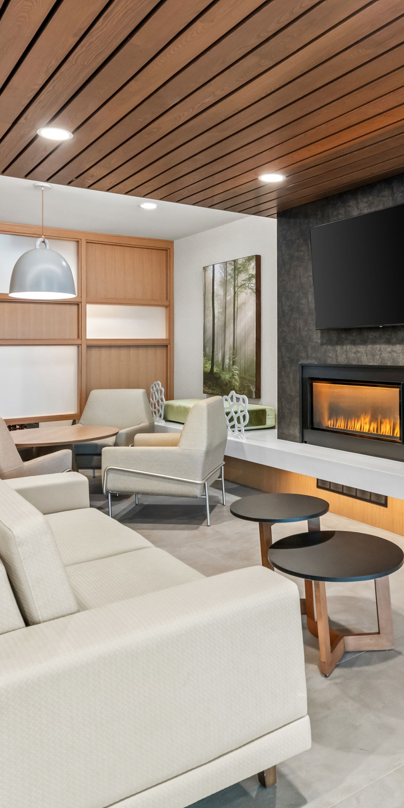 couch, tv, and fireplace in a lobby