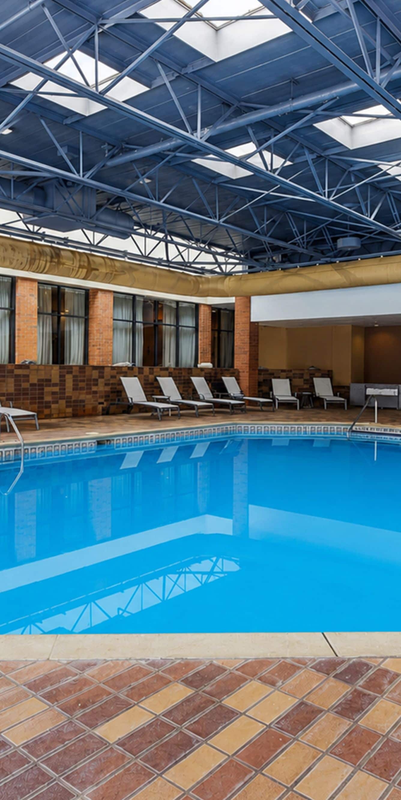Indoor pool with lounge chairs and handrail