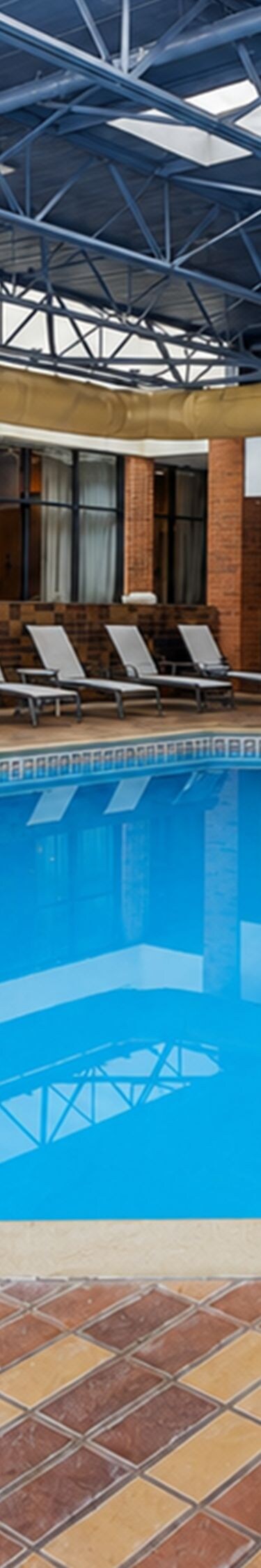Indoor pool with lounge chairs and handrail