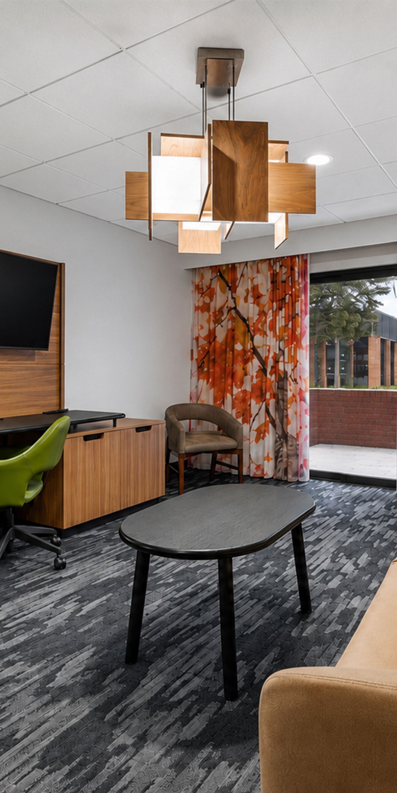 Suite living area with sofa, desk, and patio door