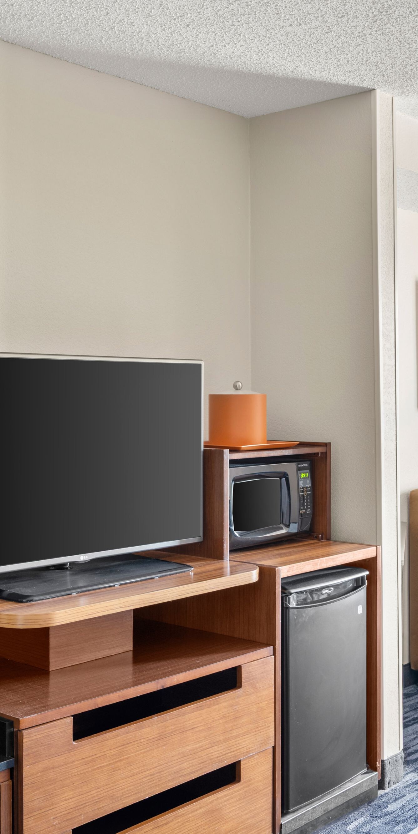 Guest room with sofa, TV, and mini fridge