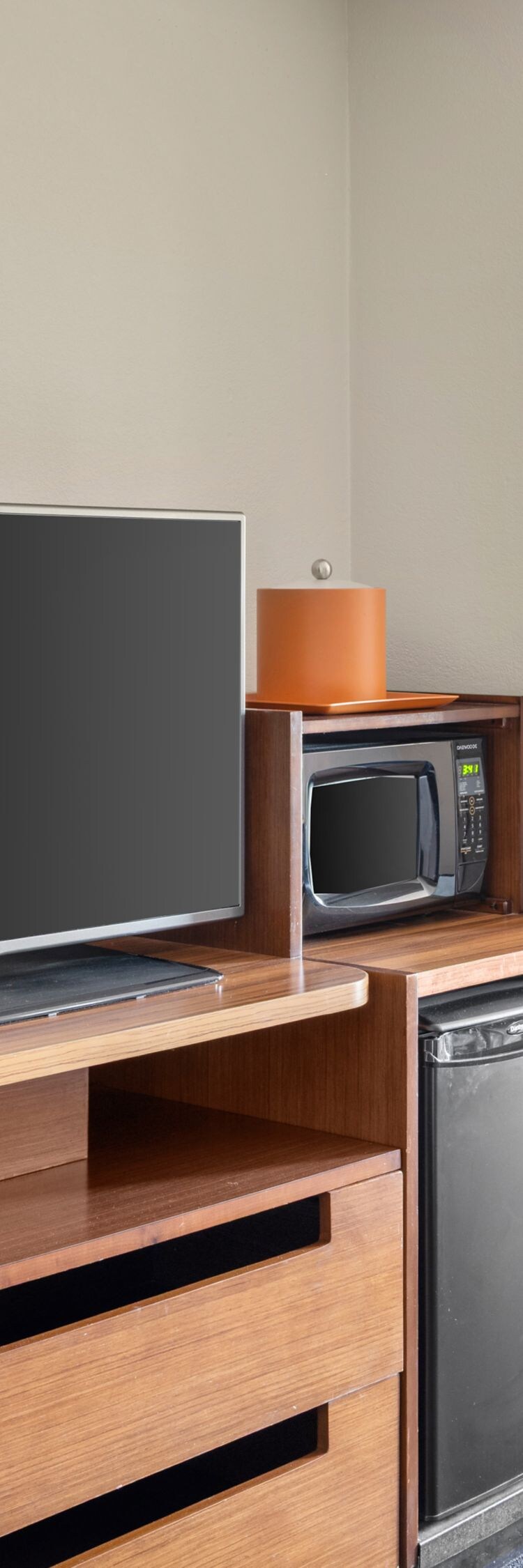 Guest room with sofa, TV, and mini fridge