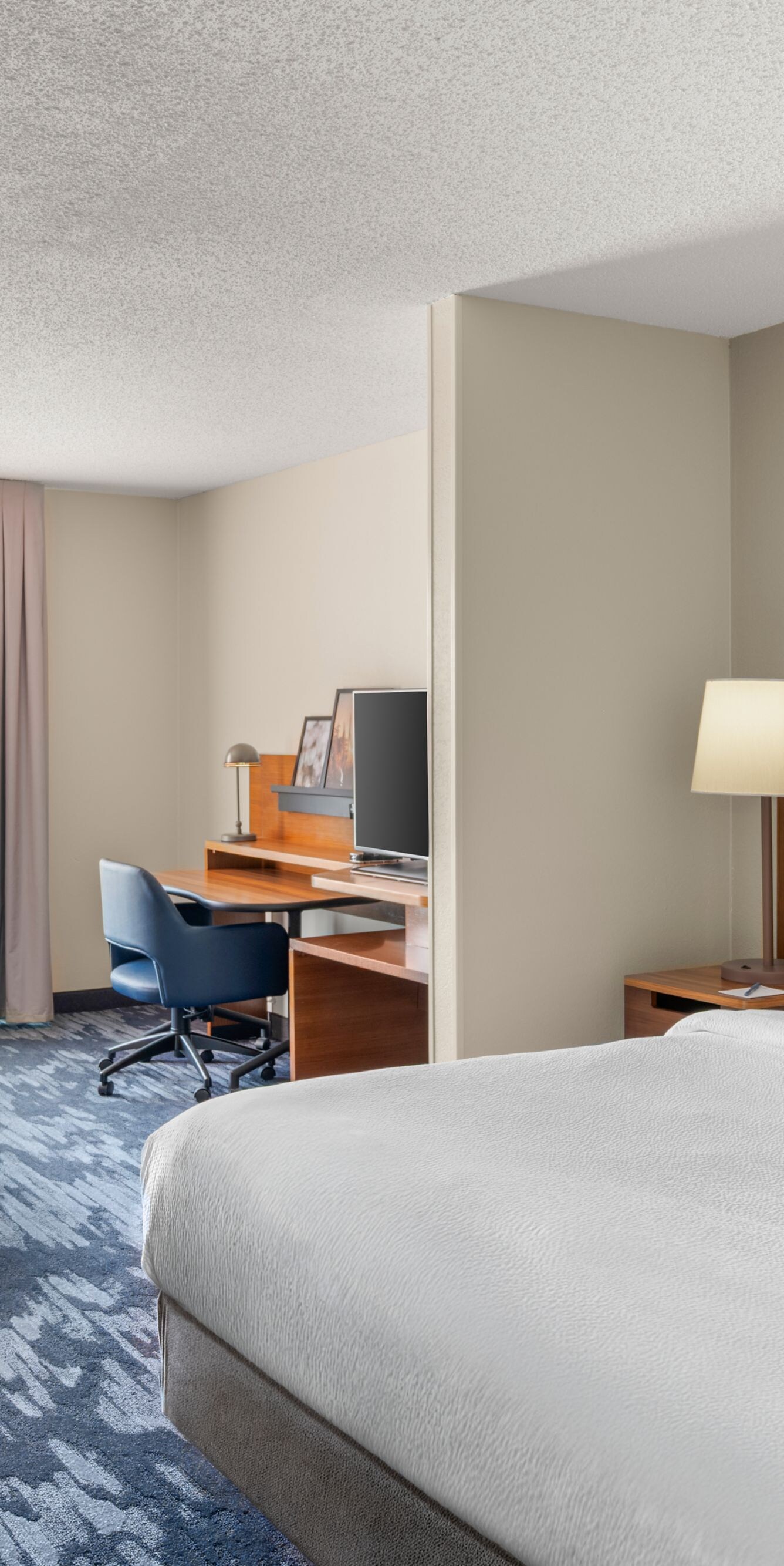 Guest room with bed, desk, and seating area