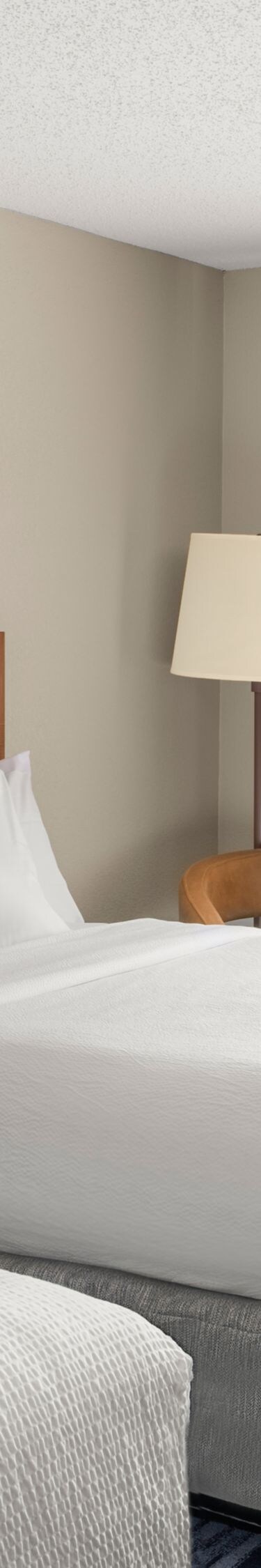 two beds, nightstands, lamps, and desk