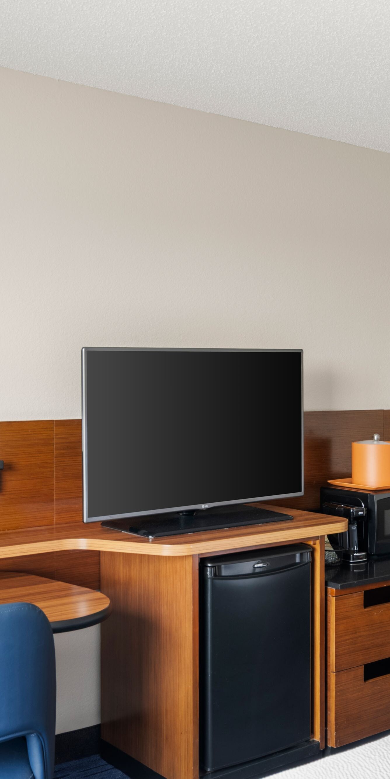 Guest room workspace with TV and mini fridge