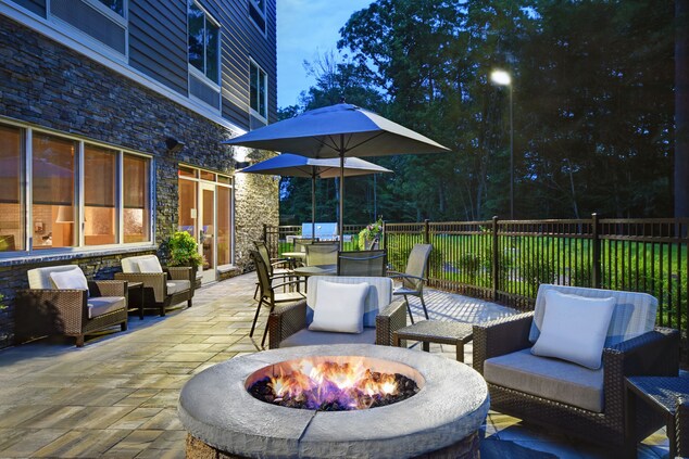 Outdoor patio with fireplace, chairs, umbrellas