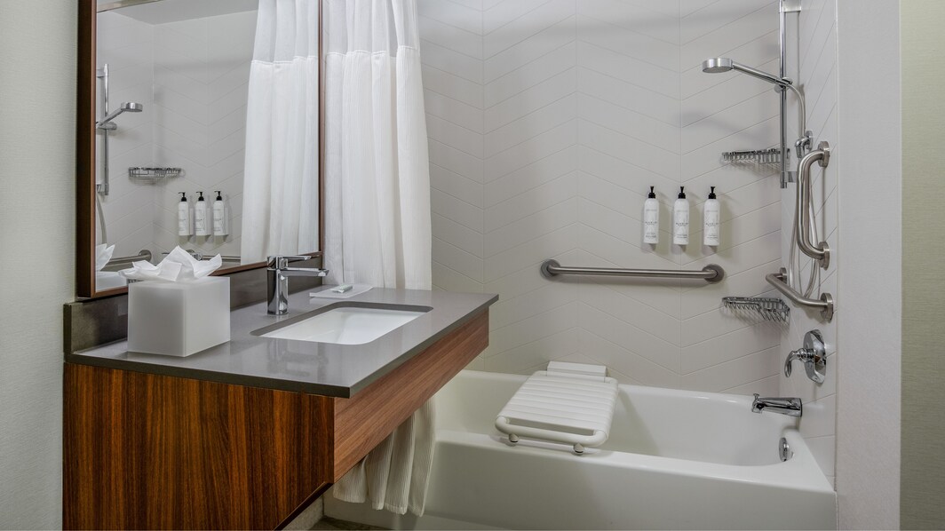 A bathroom rom with a sink and white tub
