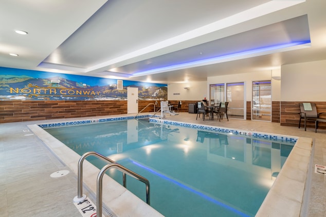indoor swimming pool with patio furniture