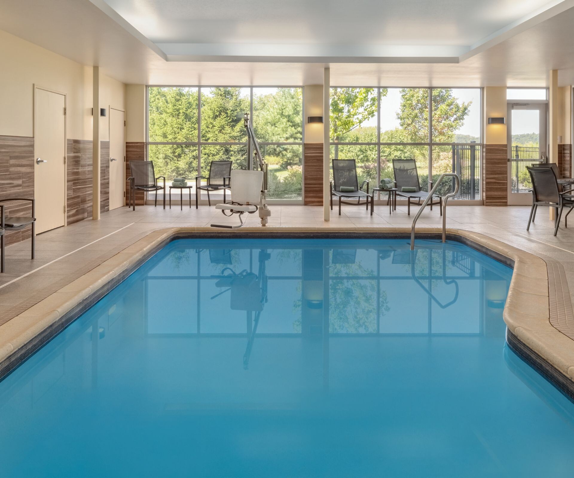 Indoor pool with lounge seating and large windows