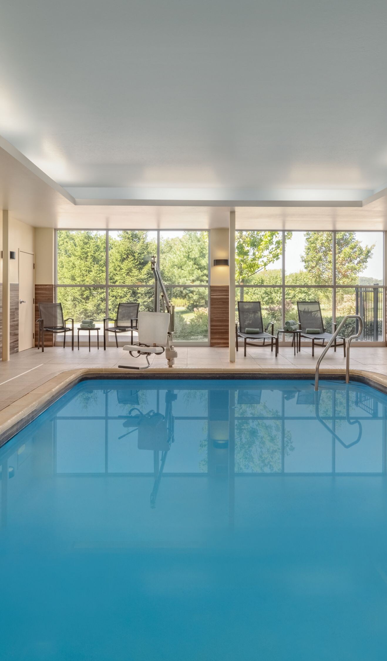 Indoor pool with lounge seating and large windows