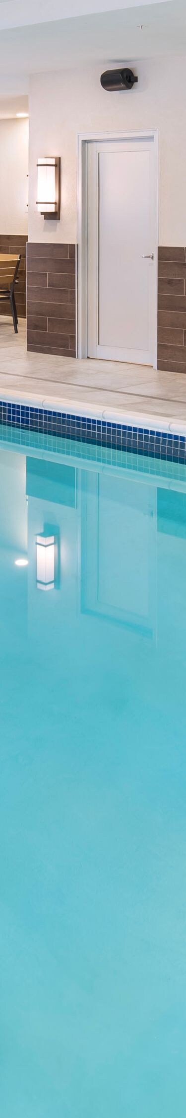Indoor pool with water feature and seating