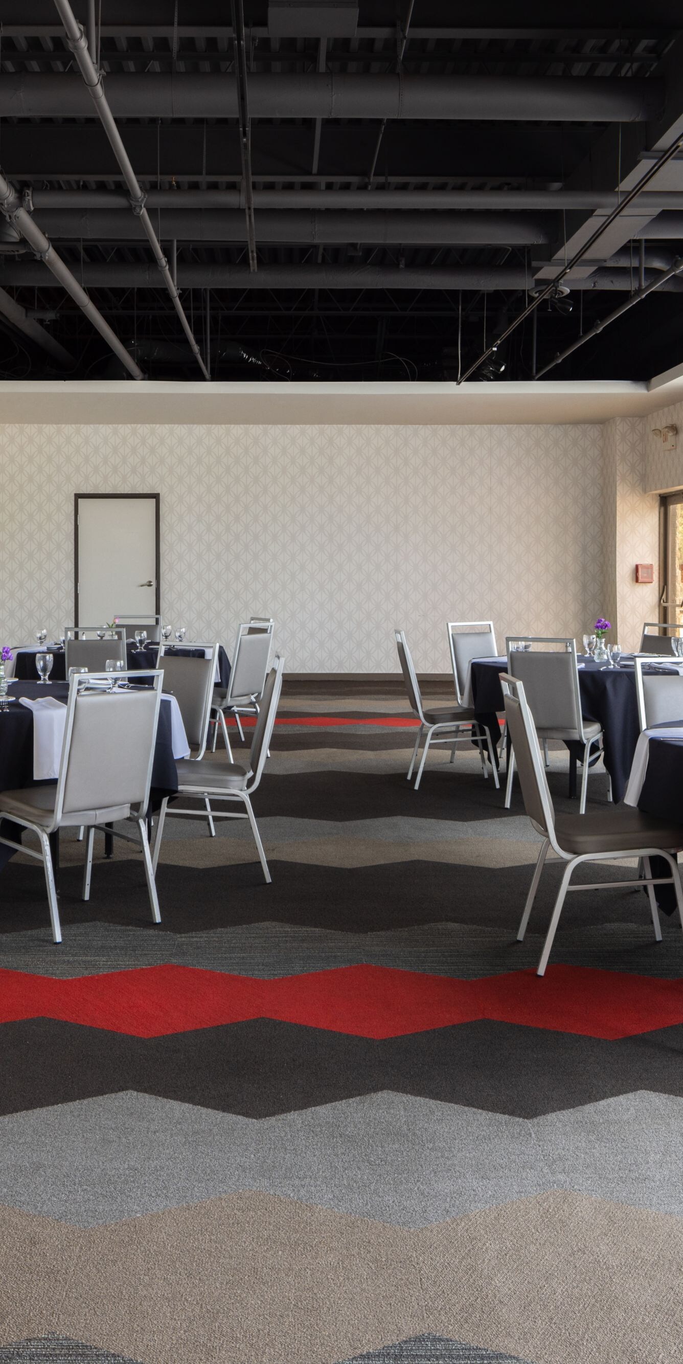 Banquet room with windows and open ceilings.