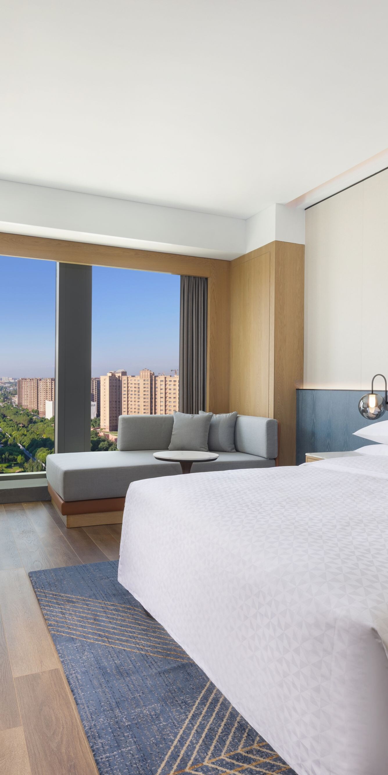 King bed with sofa, table, and city view