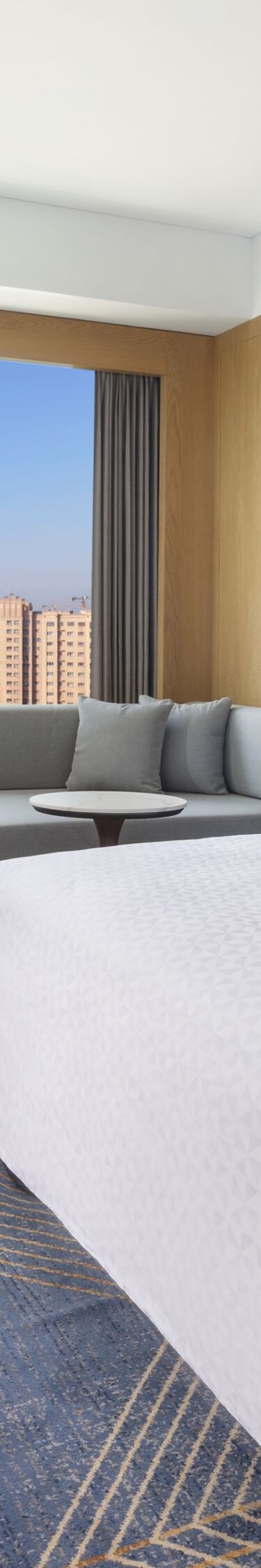 King bed with sofa, table, and city view