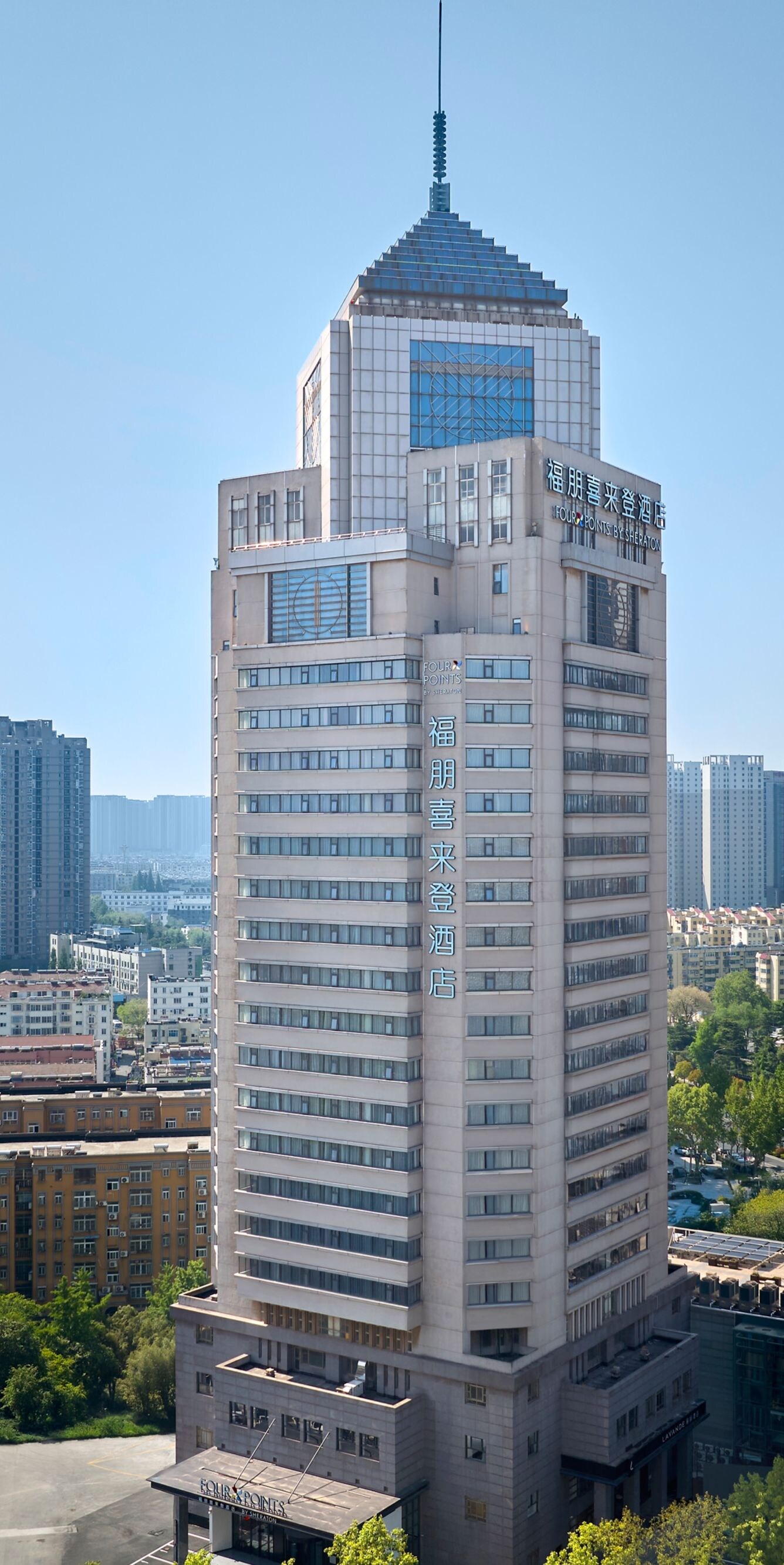 Modern hotel facade, glass windows, bright lights 