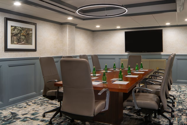Boardroom with long table and roller chairs.
