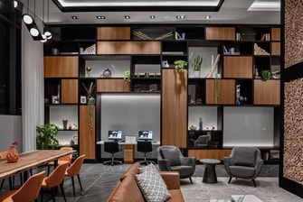 A hotel lobby with seating and a large library wal