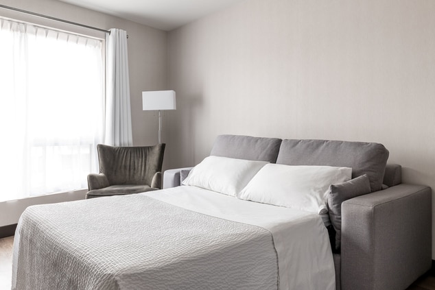Canapé-lit avec draps gris et blanc