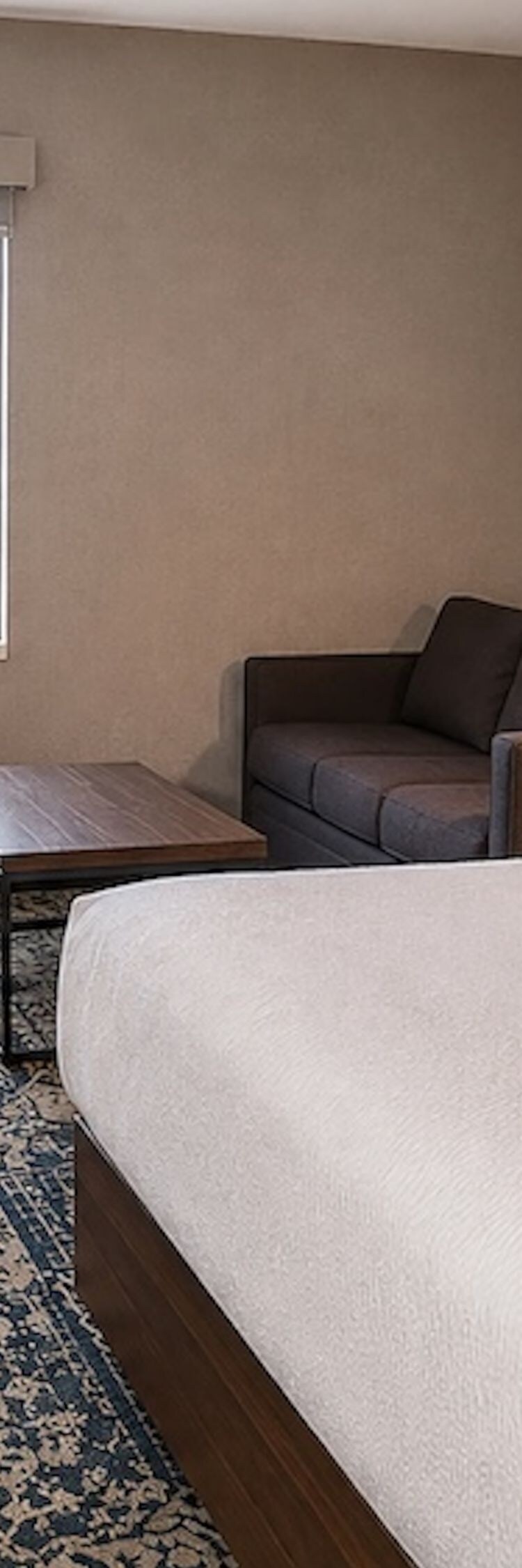 Chambre avec lit king size, canapé et vue sur la ville