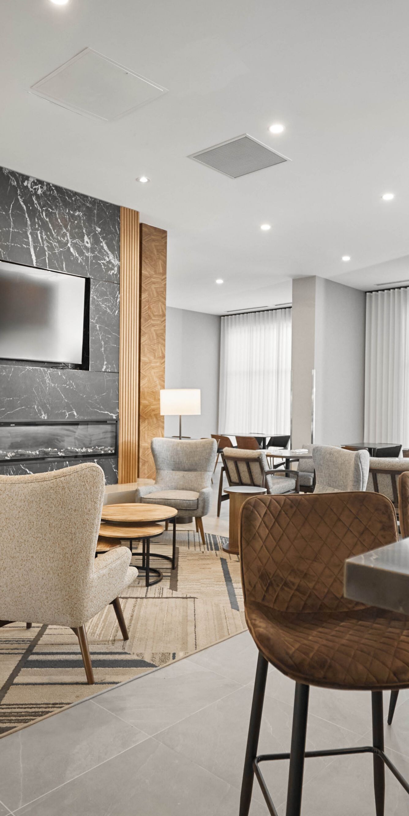 Lobby seating with large TVs is adjacent to bar.
