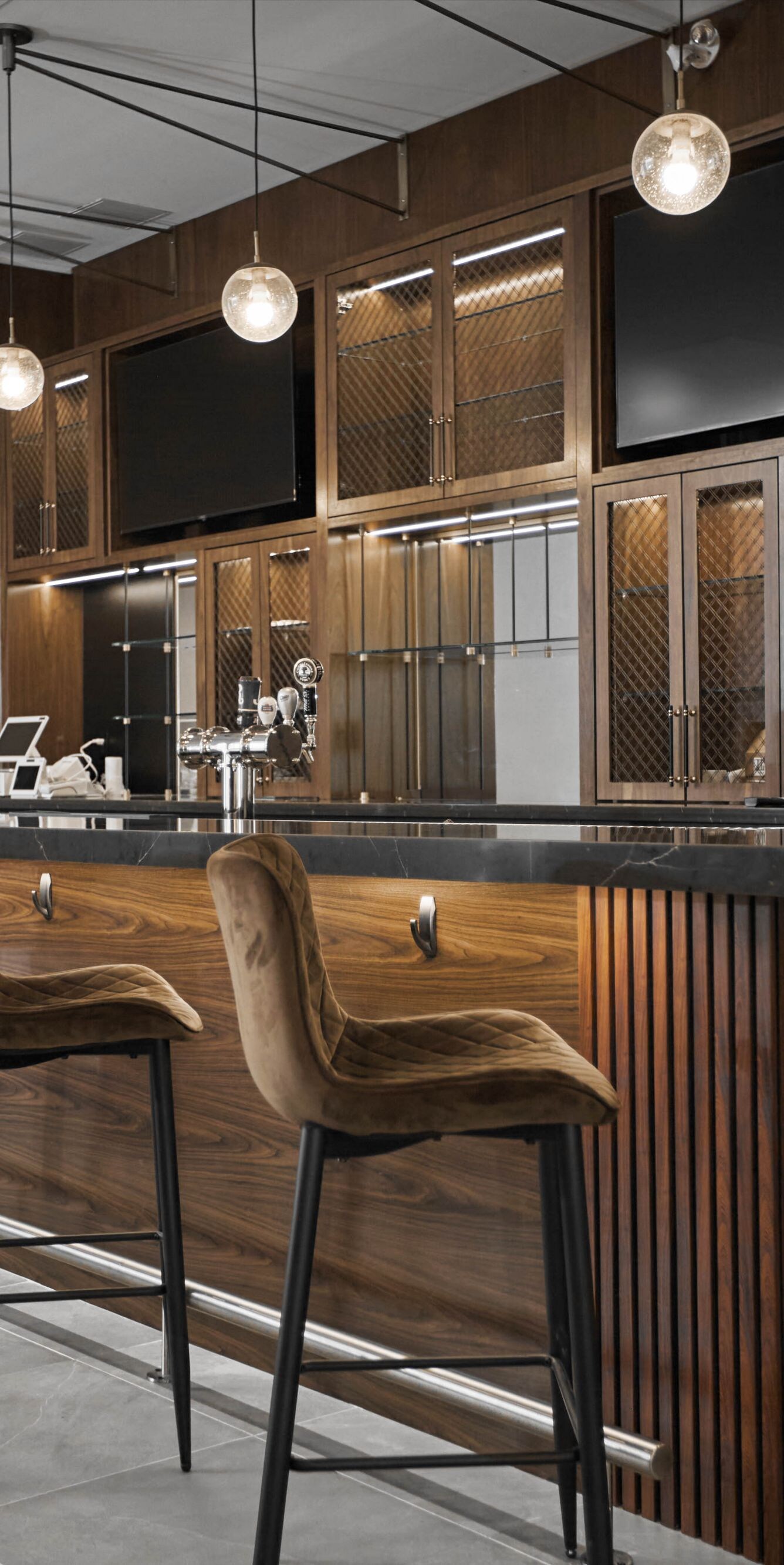 Bar, glasses, TVs, bar stools in modern bar setup