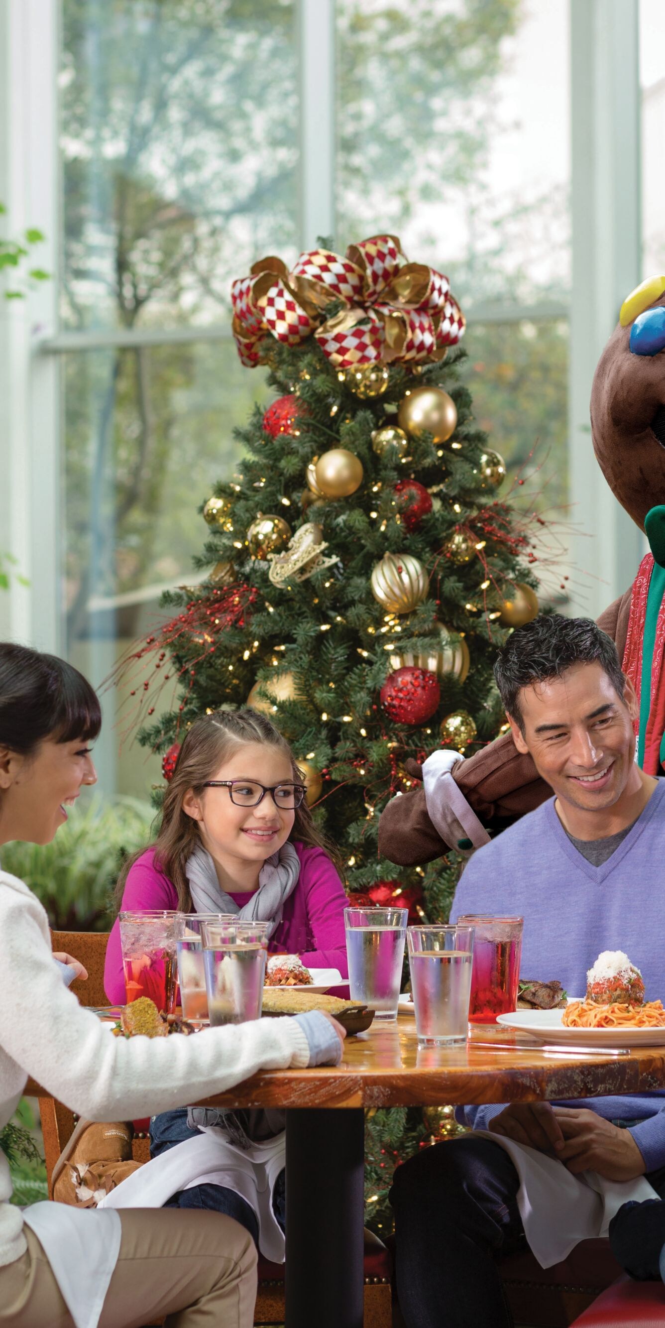 Family dining with holiday mascot and trees