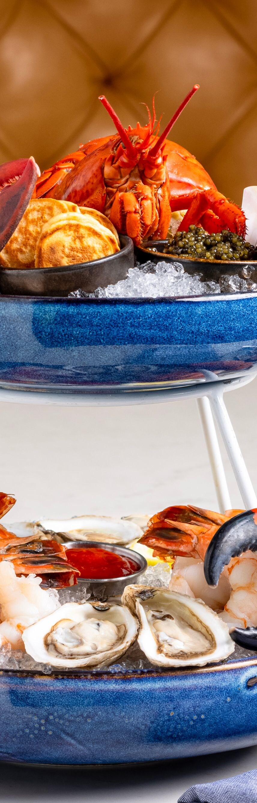 Two-tier seafood tower with lobster, clams, shrimp