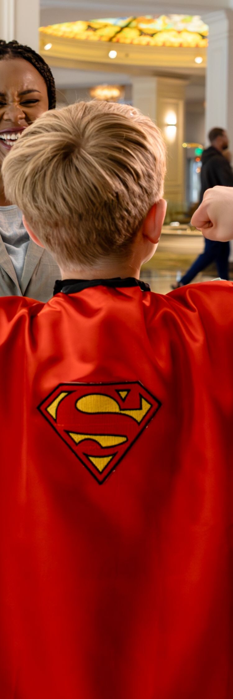 Child dressed as superhero in hotel lobby