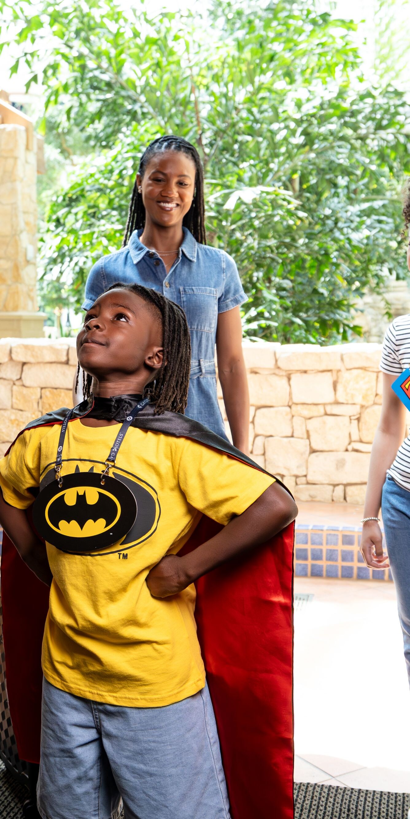 Boy wearing super hero cape and Batman badge