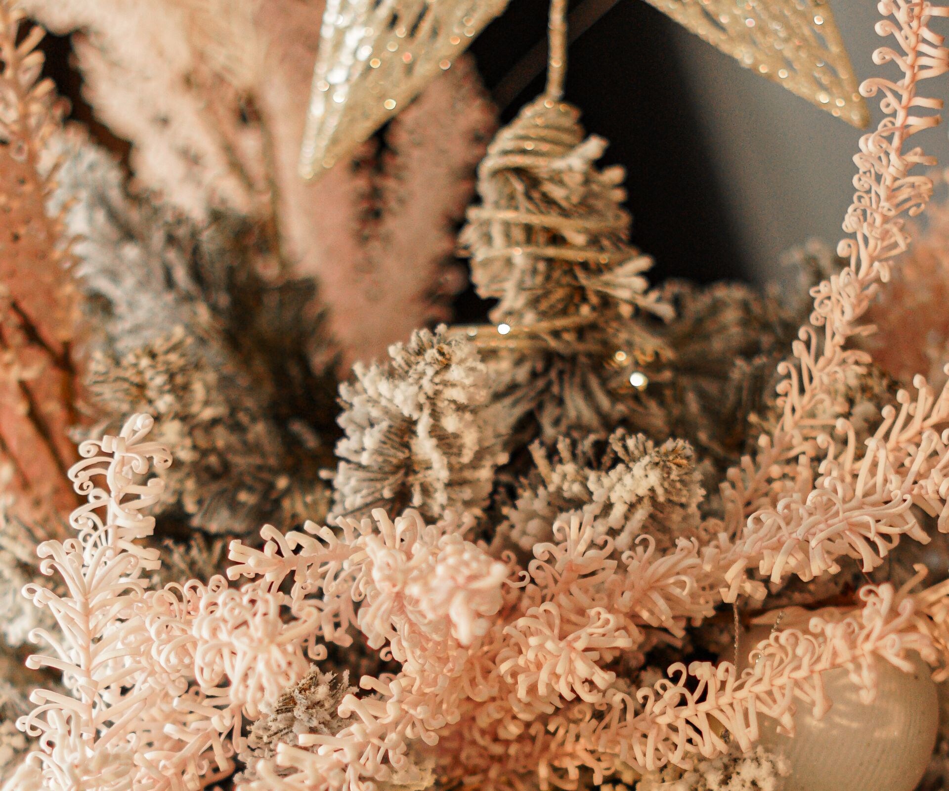 Hand decorating a pink Christmas tree