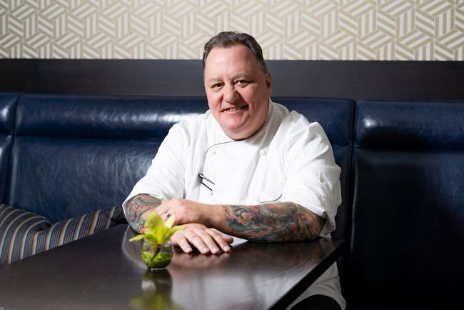 chef sitting at a table with hands crossed