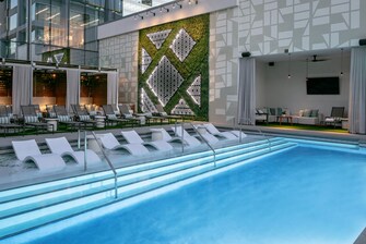 Aura Pool featuring lounge chairs and 5 cabanas