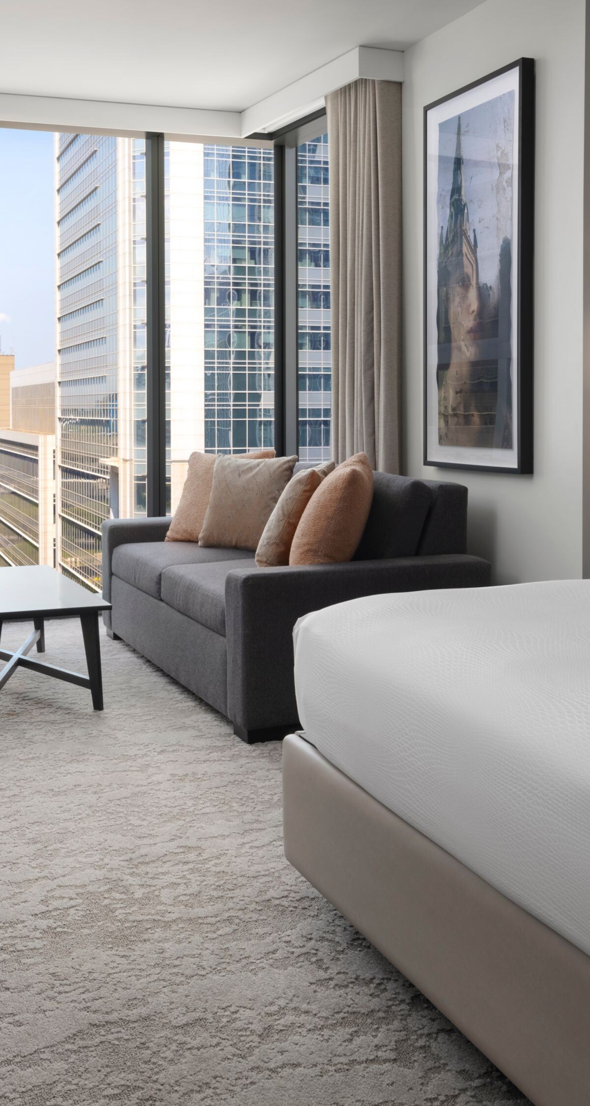 Corner king guest room at JW Marriott Charlotte with a king bed, sofa, and skyline views