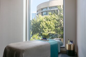 Spa treatment room with a bed and large window